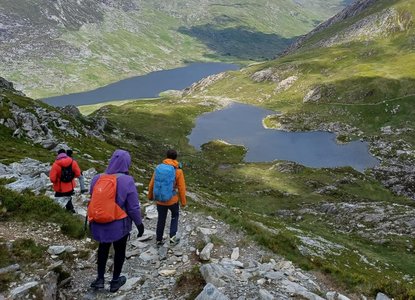 Hikers with Black Girls Hike walk down a mountain towards a couple of lakes