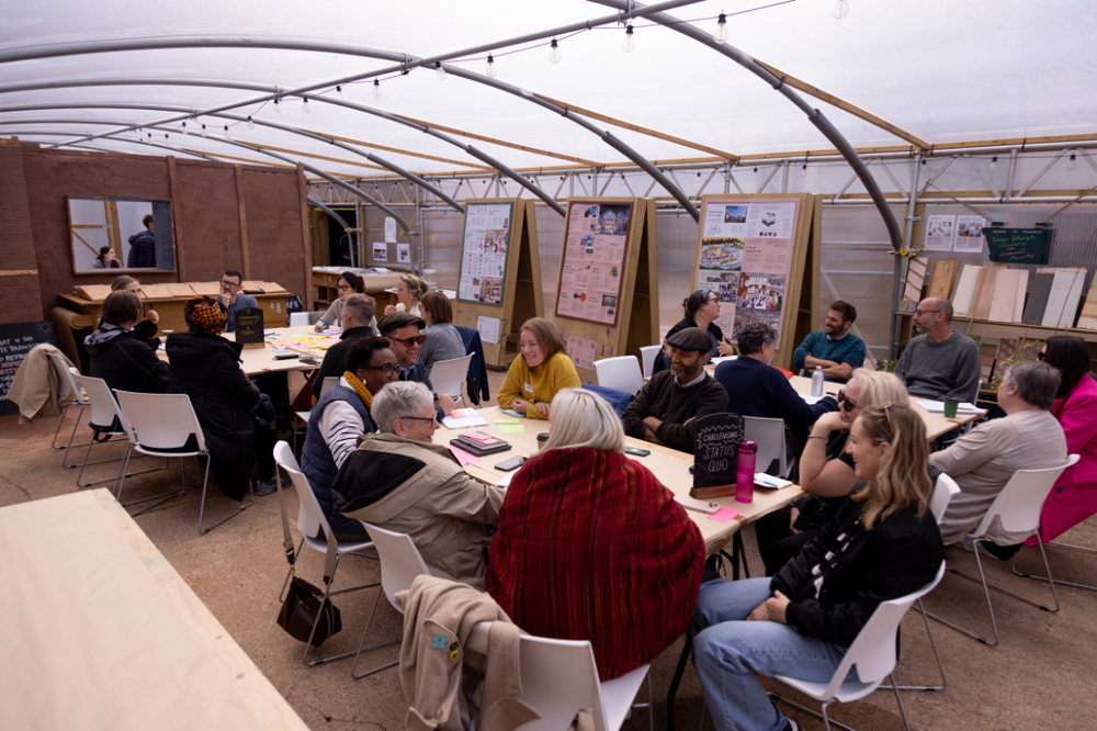 Groups of people convened by Esmée Fairbairn Foundation and Civic Square sat around tables having a discussion.