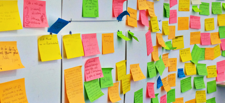 White wall with lots of colourful post-it notes